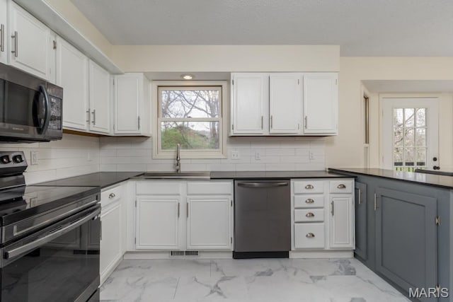 212 Tremont Dr, Waynesville, MO 65583 - kitchen featuring black appliances, a sink, light marble finish floors, dark countertops, and white cabinetry