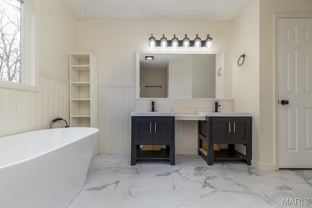 212 Tremont Dr, Waynesville, MO 65583 - bathroom with marble look tile flooring, double vanity, a soaking tub, and a wainscoted wall
