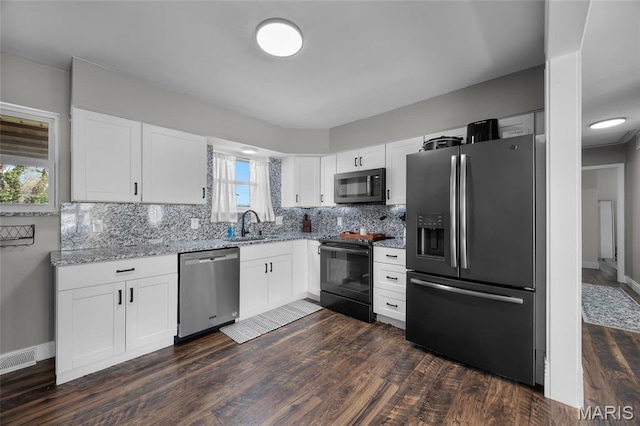 9748 Mackenzie Rd, Saint Louis, MO 63123 - kitchen featuring stainless steel appliances, light stone countertops, tasteful backsplash, dark wood-style flooring, and white cabinetry