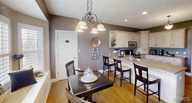 kitchen featuring appliances with stainless steel finishes, a peninsula, light wood-style floors, light countertops, and recessed lighting