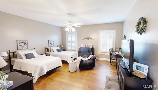bedroom featuring light wood-style flooring, baseboards, and ceiling fan