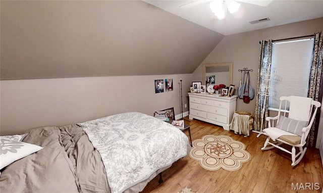 bedroom featuring wood finished floors, lofted ceiling, and a ceiling fan