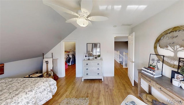 bedroom with light wood-style floors, a spacious closet, and ceiling fan