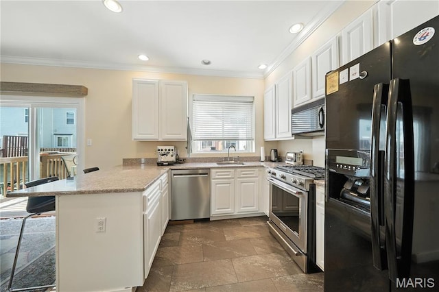 5784 Westminster Pl, Saint Louis, MO 63112 - kitchen featuring black appliances, a peninsula, crown molding, white cabinets, and stone tile flooring