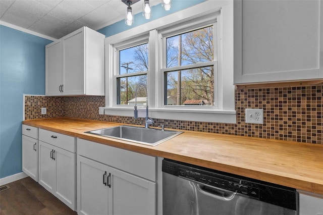 kitchen with butcher block counters, dishwasher, a sink, and backsplash