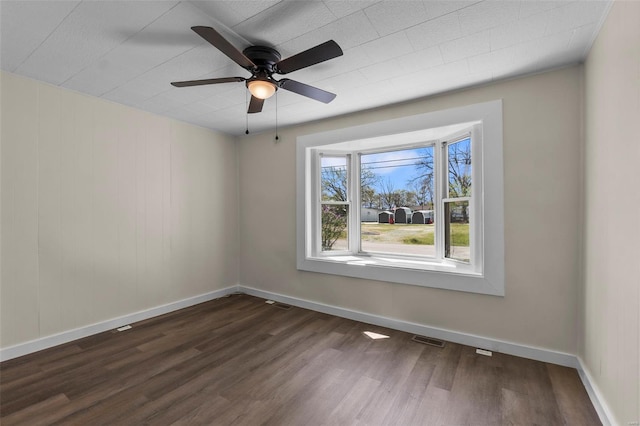 unfurnished room featuring dark wood-style floors, baseboards, and ceiling fan