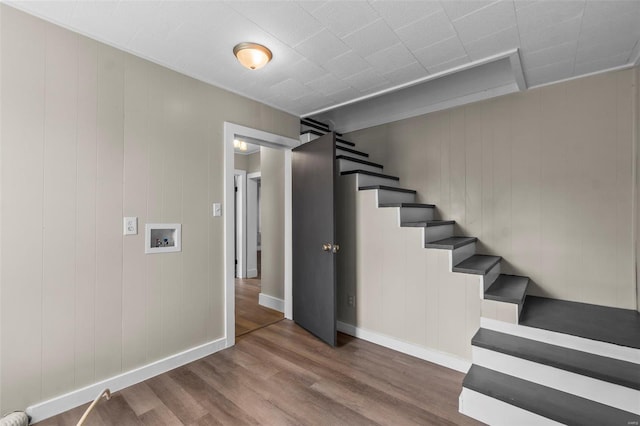 stairs with wood finished floors and baseboards