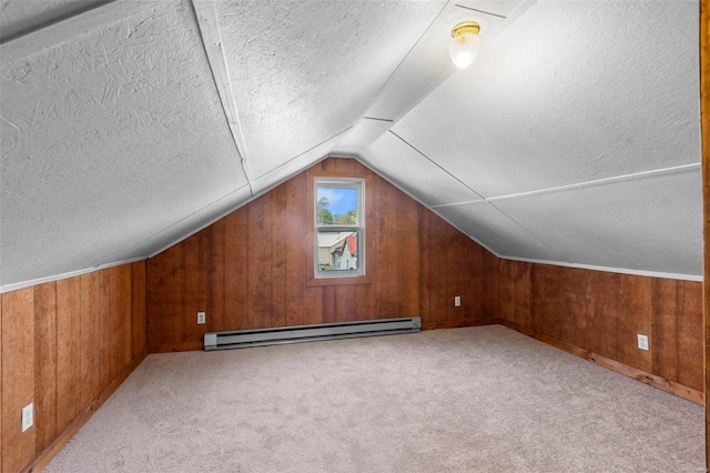 bonus room featuring a baseboard radiator, lofted ceiling, carpet flooring, wood walls, and a textured ceiling