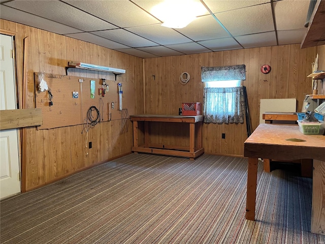 interior space with wood walls, carpet floors, and a paneled ceiling