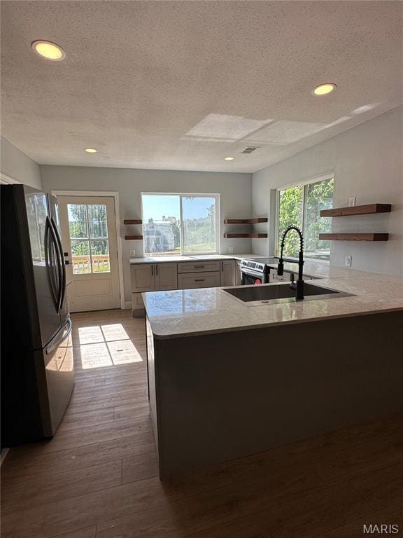 403 Broadway St, Waynesville, MO 65583 - kitchen with open shelves, freestanding refrigerator, a sink, a peninsula, and a textured ceiling