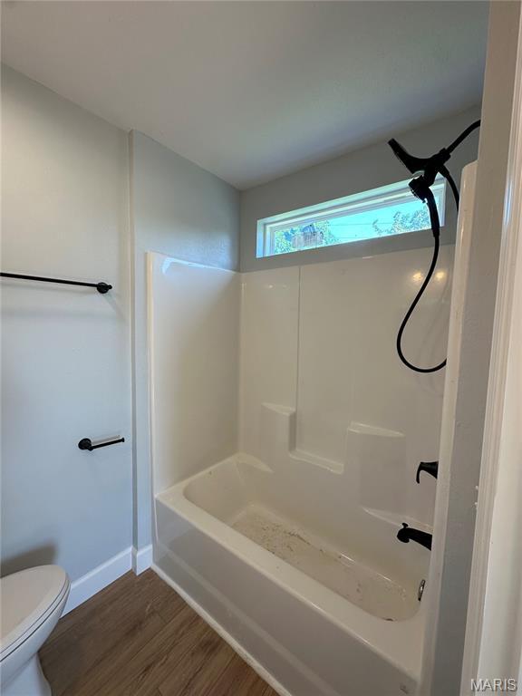 403 Broadway St, Waynesville, MO 65583 - bathroom featuring toilet, baseboards, wood finished floors, and shower / tub combination