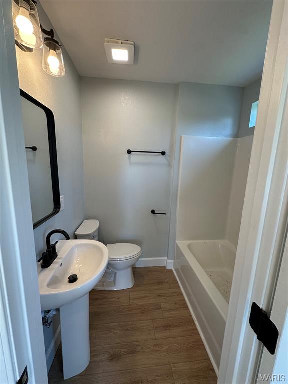 403 Broadway St, Waynesville, MO 65583 - bathroom with toilet, wood finished floors, and baseboards