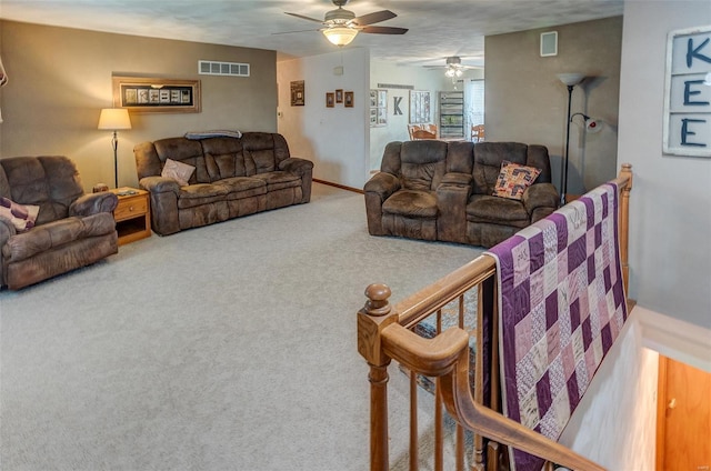 carpeted living area with a ceiling fan and baseboards