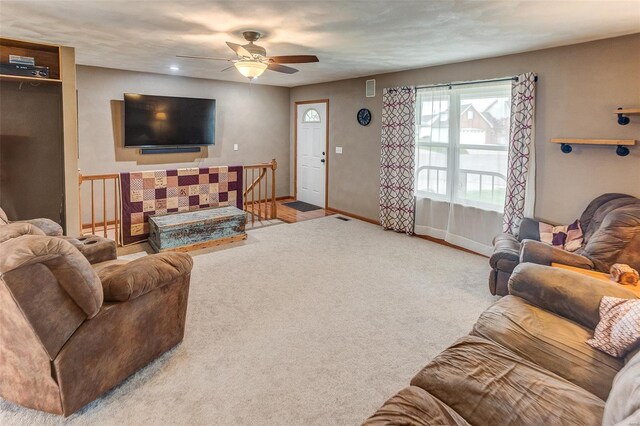 carpeted living room with a ceiling fan and baseboards
