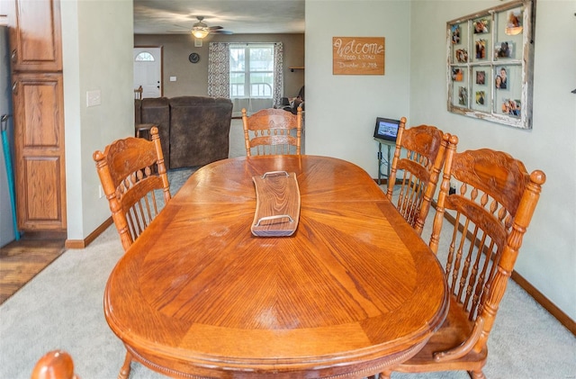 dining space with carpet, baseboards, and ceiling fan