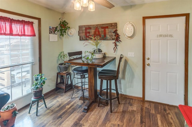 dining space featuring wood finished floors, baseboards, and a ceiling fan