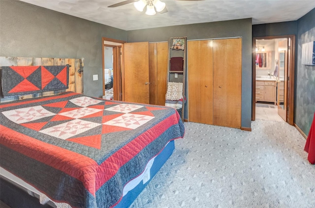 carpeted bedroom featuring multiple closets and a ceiling fan