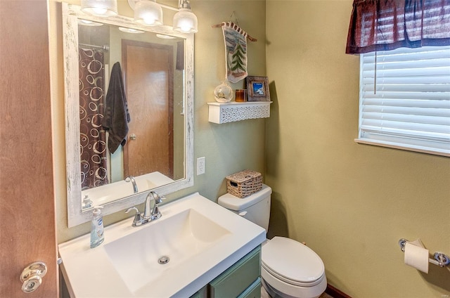 bathroom with toilet, vanity, and a shower with shower curtain