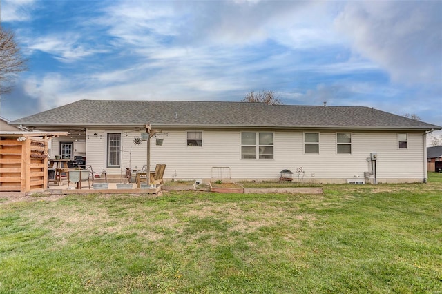 back of property featuring a patio area, a lawn, and a shingled roof