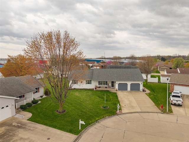 view of front facade with a front yard, driveway, and a garage