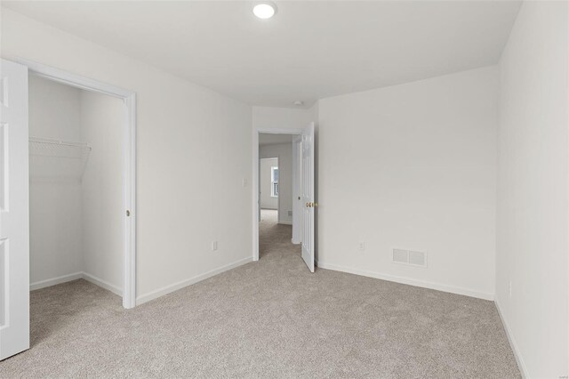 407 Fleming Cir, Wentzville, MO 63385 - unfurnished bedroom with carpet floors, a walk in closet, baseboards, and a closet