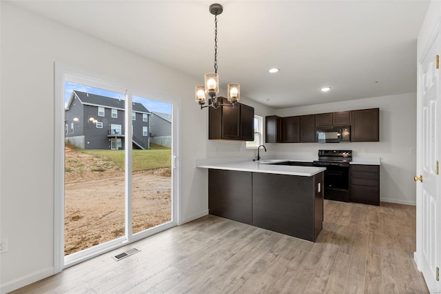 407 Fleming Cir, Wentzville, MO 63385 - kitchen featuring black appliances, dark brown cabinets, light wood-style flooring, a chandelier, and recessed lighting