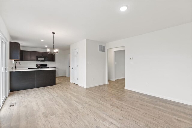 407 Fleming Cir, Wentzville, MO 63385 - unfurnished living room featuring a chandelier, light wood-type flooring, recessed lighting, baseboards, and a sink