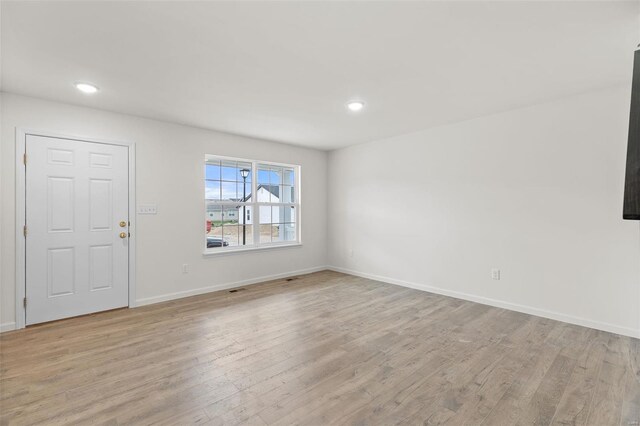 407 Fleming Cir, Wentzville, MO 63385 - unfurnished living room with light wood-style flooring, recessed lighting, and baseboards