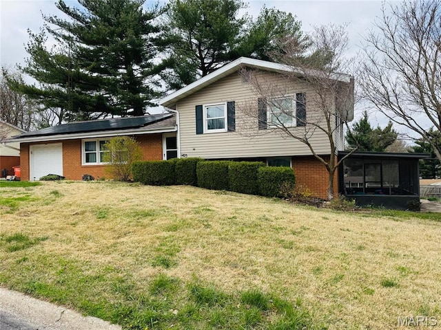 1423 Shelley Dr, Vandalia, IL 62471 - tri-level home featuring a garage, a sunroom, a front lawn, and brick siding