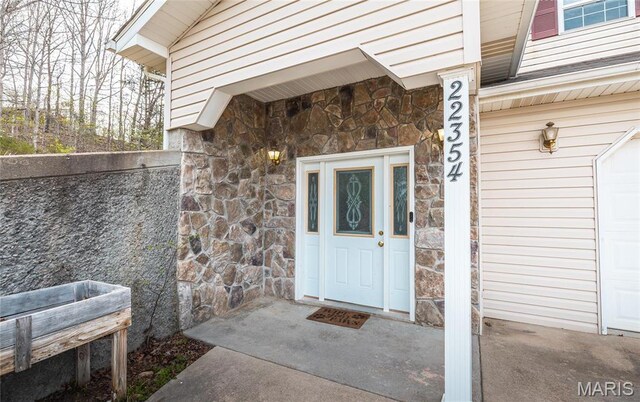 22354 Target Rd, Saint Robert, MO 65584 - doorway to property with stone siding and a garage