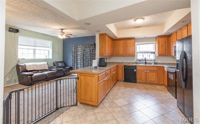 22354 Target Rd, Saint Robert, MO 65584 - kitchen featuring black appliances, open floor plan, a peninsula, a textured ceiling, and a tray ceiling
