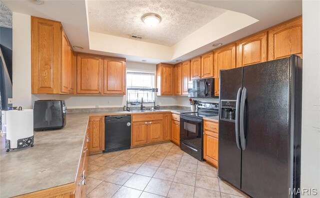 22354 Target Rd, Saint Robert, MO 65584 - kitchen with black appliances, a tray ceiling, a textured ceiling, a sink, and light countertops