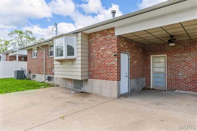 1220 Spring Valley Dr, Florissant, MO 63033 - view of home's exterior with a patio, brick siding, central AC unit, a ceiling fan, and fence