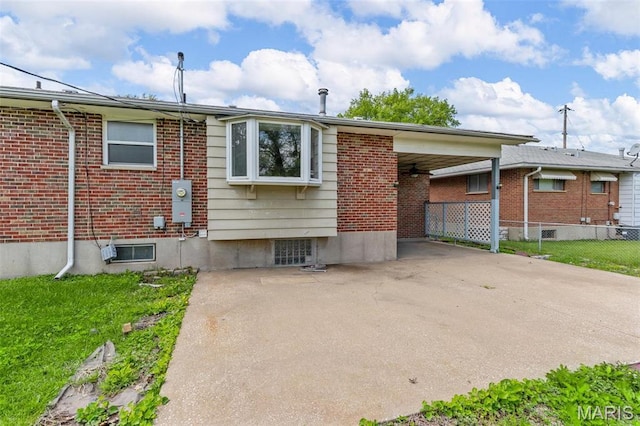 1220 Spring Valley Dr, Florissant, MO 63033 - rear view of property featuring fence, ceiling fan, an attached carport, and brick siding