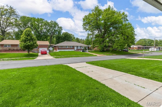 1220 Spring Valley Dr, Florissant, MO 63033 - view of green lawn featuring driveway and a garage