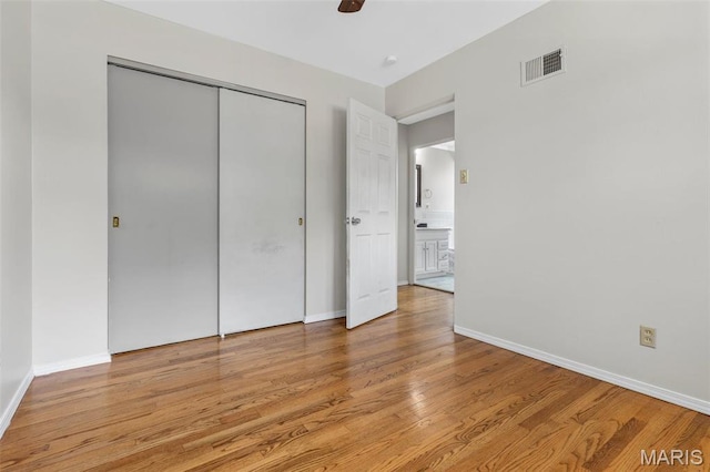 1220 Spring Valley Dr, Florissant, MO 63033 - unfurnished bedroom featuring light wood-style floors, a closet, baseboards, and a ceiling fan