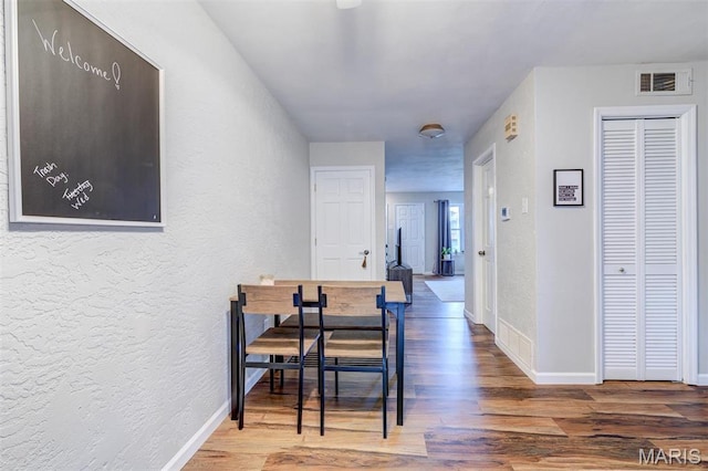 10161 Squire Meadows Dr Unit C, Saint Louis, MO 63123 - hall featuring a textured wall, wood finished floors, and baseboards