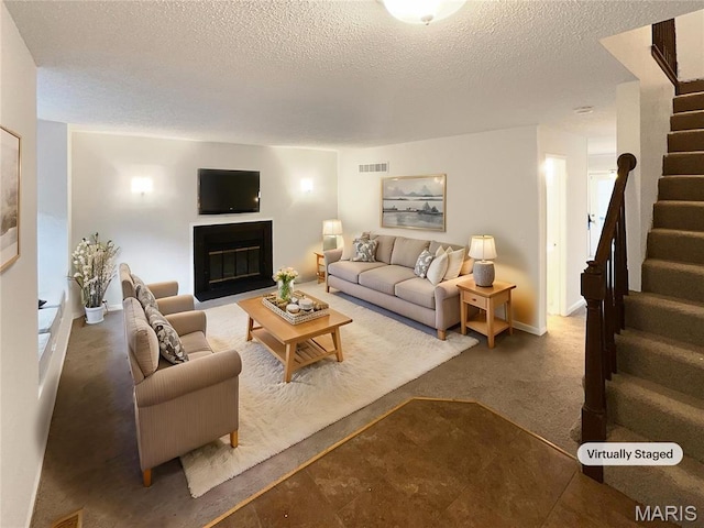 26 Thistledale Ct Unit H, Saint Peters, MO 63376 - carpeted living area featuring stairway, a glass covered fireplace, and a textured ceiling