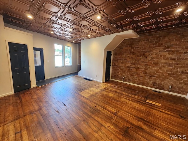 4713 Virginia Ave, Saint Louis, MO 63111 - spare room featuring baseboards, brick wall, hardwood / wood-style flooring, and an ornate ceiling