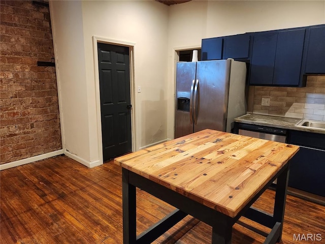 4713 Virginia Ave, Saint Louis, MO 63111 - kitchen with stainless steel appliances, butcher block counters, dark wood finished floors, blue cabinetry, and baseboards