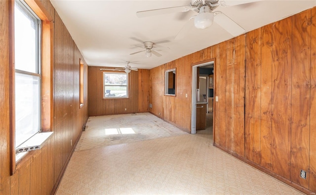 104 E Jefferson Ave, Richland, MO 65556 - empty room featuring wooden walls, ceiling fan, light floors, and baseboards