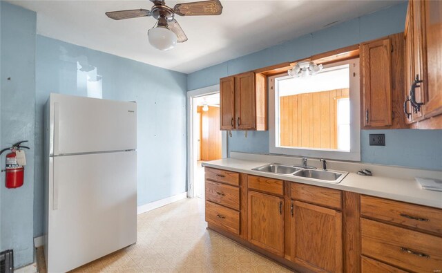 104 E Jefferson Ave, Richland, MO 65556 - kitchen featuring freestanding refrigerator, a sink, brown cabinets, and light countertops