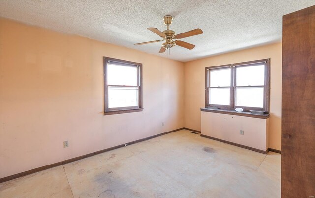 104 E Jefferson Ave, Richland, MO 65556 - empty room featuring healthy amount of natural light, a textured ceiling, a ceiling fan, and baseboards