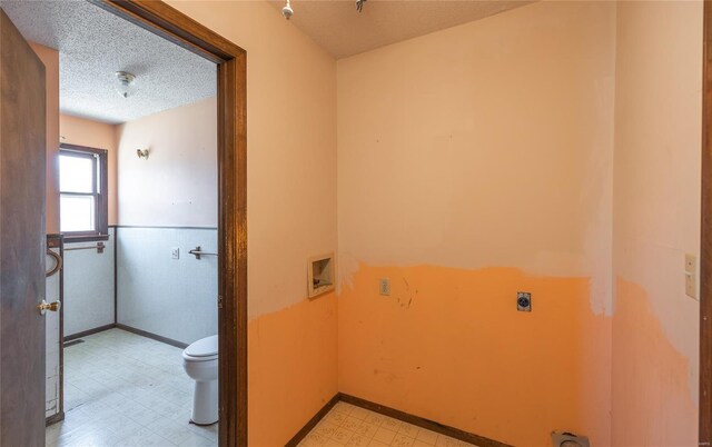 104 E Jefferson Ave, Richland, MO 65556 - clothes washing area with hookup for an electric dryer, light floors, a textured ceiling, a wainscoted wall, and hookup for a washing machine