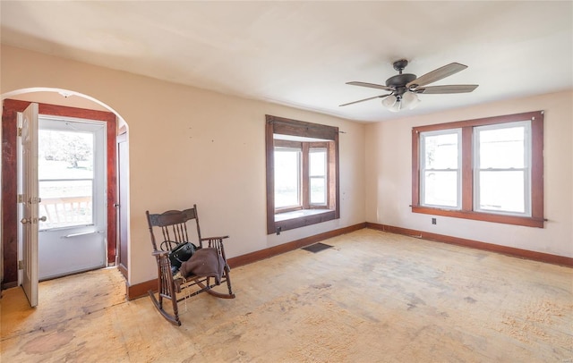 104 E Jefferson Ave, Richland, MO 65556 - unfurnished room featuring arched walkways, a ceiling fan, and baseboards