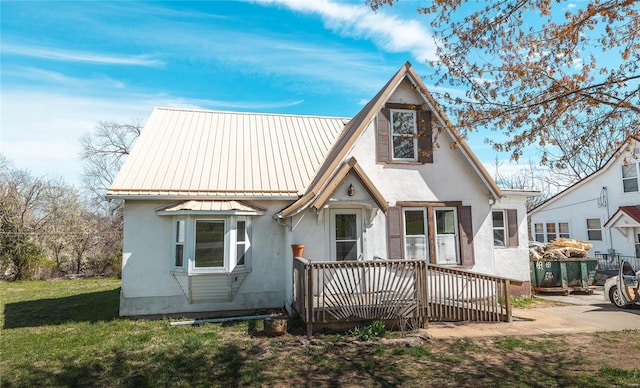 104 E Jefferson Ave, Richland, MO 65556 - view of front of house with stucco siding, a wooden deck, and metal roof