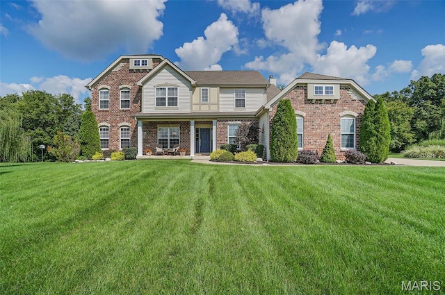 view of front of house featuring brick siding and a front yard