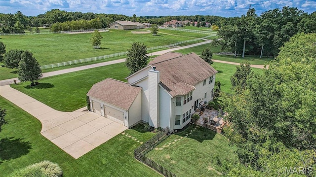 aerial view of property and surrounding area with a tree filled landscape