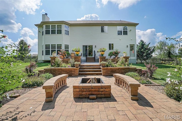 rear view of property featuring a patio area, a fire pit, and a chimney