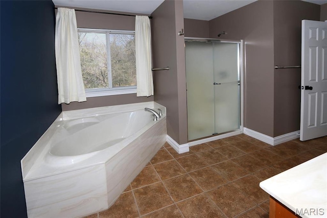 full bath with a shower stall, a bath, baseboards, and tile patterned flooring
